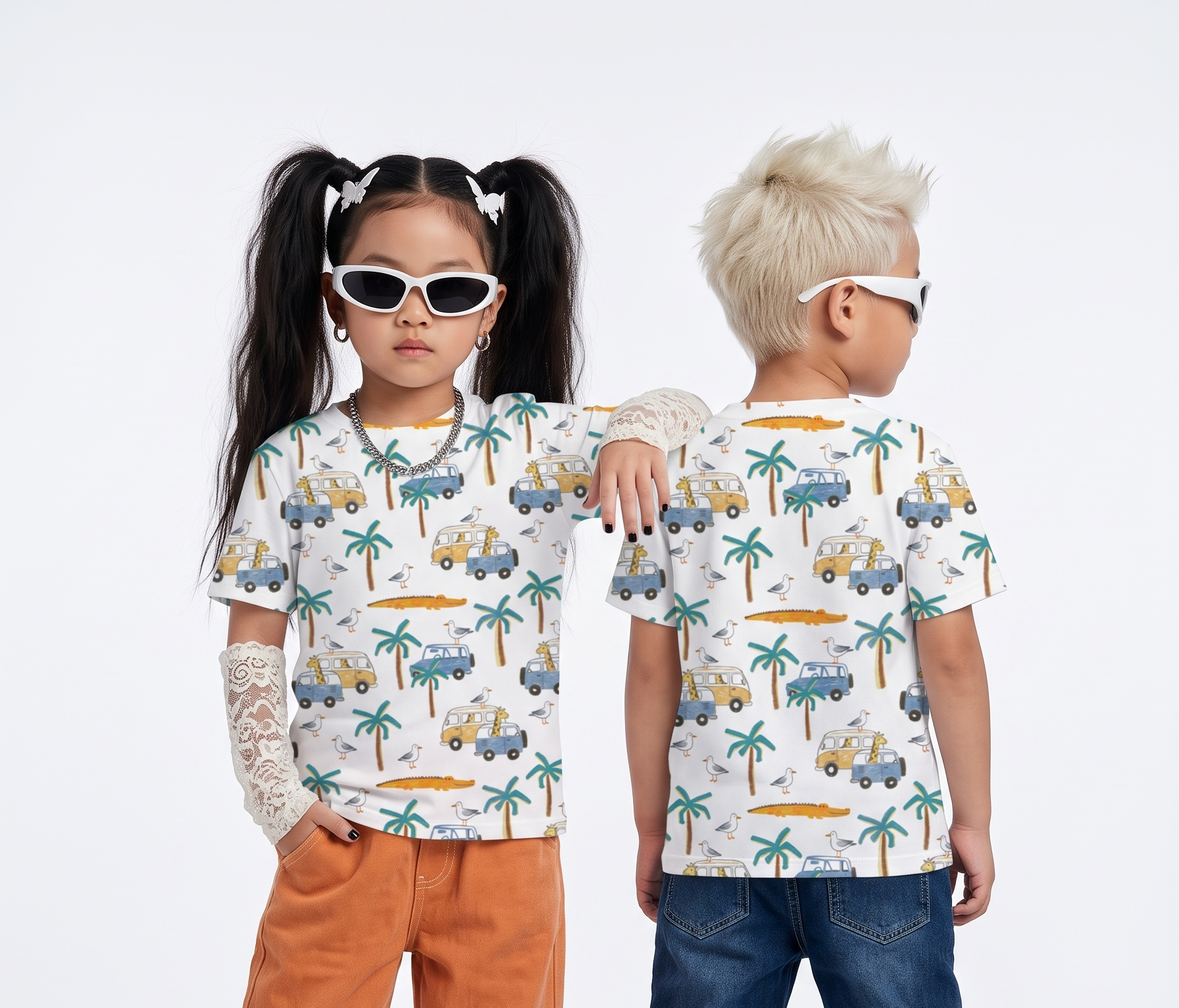 Two children modeling matching short-sleeve t-shirts with a white base and a colorful tropical car-and-palm-tree print, photographed against a clean light gray studio background.