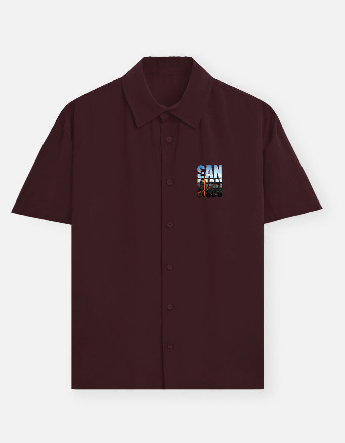 Maroon shirt with a graphic design on the chest against a white background