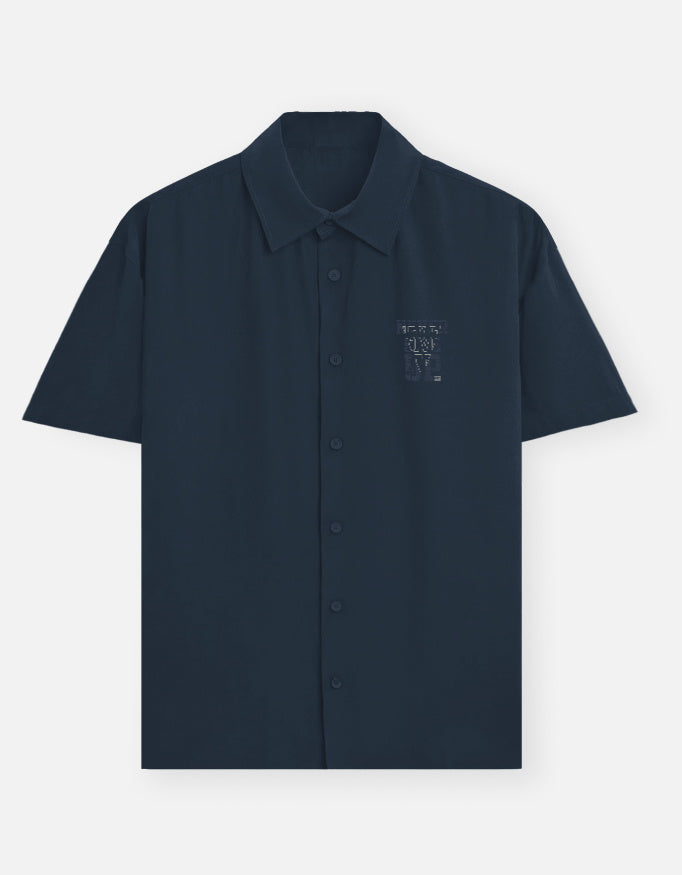  blue shirt with an owl emblem on a light gray background